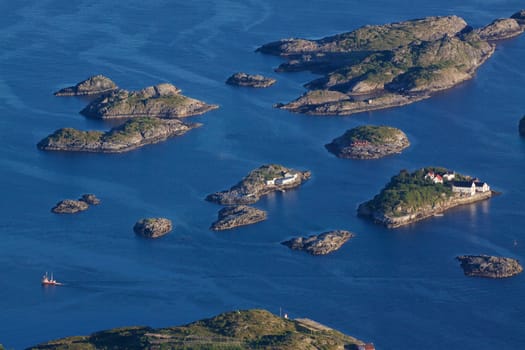 Bird eye view of fishing boats sailing between scenic islets near Henningsvaer on Lofoten islands in Norway