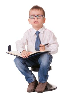 Small clever boy thinks his wishes to write them in notebook isolated on white background