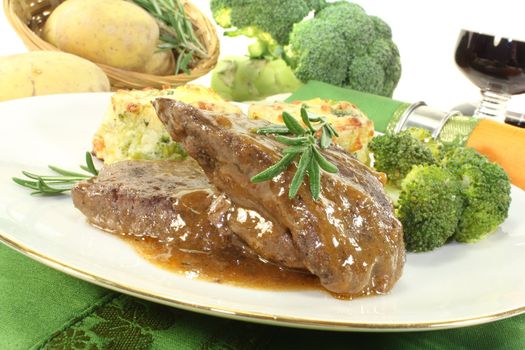 Venison medallions with gratin potatoes, broccoli and rosemary branch