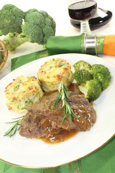 freshly cooked Venison medallions with gratin potatoes, broccoli and rosemary branch