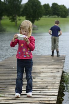 Young girl playing computer game in nature