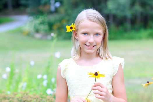Young Blond Girl Holding a Flower in her Hands