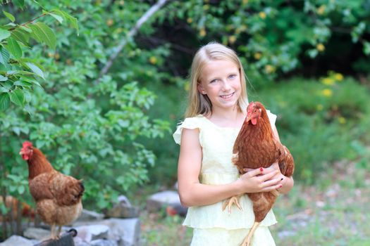 Young Blonde Girl in the Garden caring for Her Chickens in a Yellow Dress