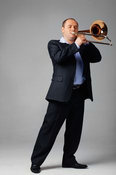 Portrait of a young man playing his trombone.