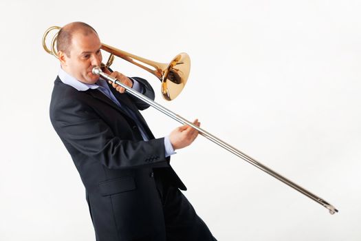 Portrait of a young man playing his trombone.