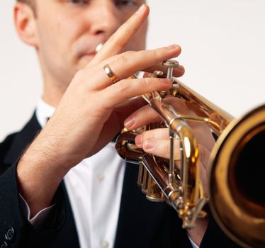 Closeup of the hands of an European musician playing the trumpet