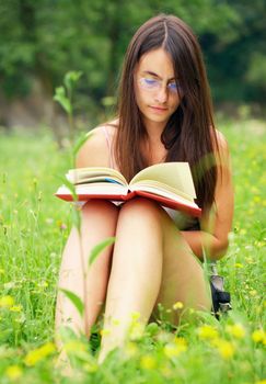 Young woman reading a book outdoors.