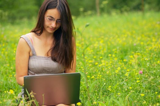 Young woman using her laptop outdoors.