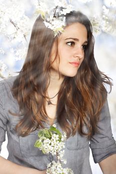 Portrait of a Beautiful Girl with Flowers from a Blooming Tree