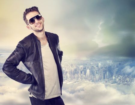 Young handsome man wearing sunglasses on top of the city