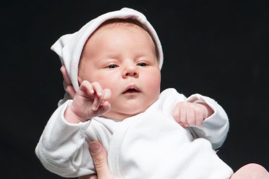 baby in mother's hands over black