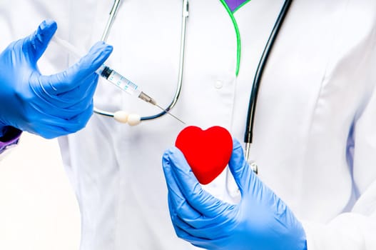 Doctors hands with Syringe and red heart