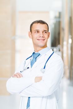 Portrait of a doctor standing in the office and crossed his arms