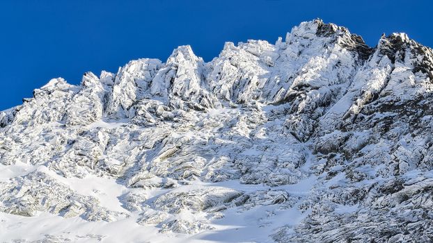 Winter rocky mountain peak in High Tatras, Slovakia, with blue sky background