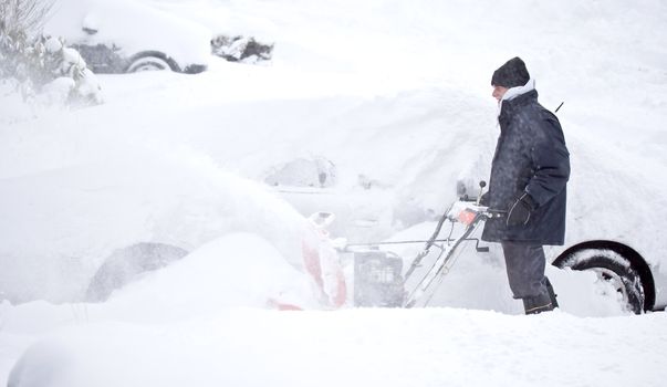 Man blowing snow to clear out sidewalk and driveway