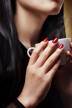 Beautiful woman holding a hot beverage (coffee - tea)
