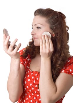 Girl putting facial powder on her face, white background.