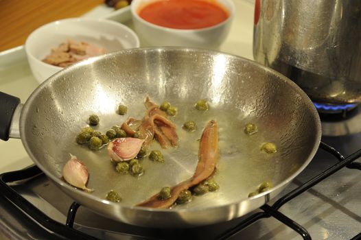 The making of a typical italian receipt, spaghetti with puttanesca sauce