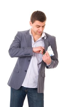 Young man putting money into pocket isolated on white background