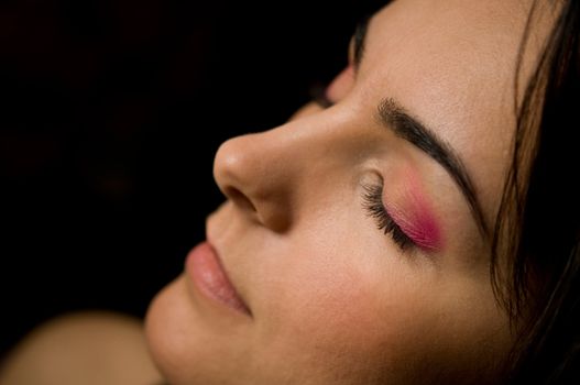 Profile of attractive beauty woman on dark background. Shallow depth of field. Focus on the left eye