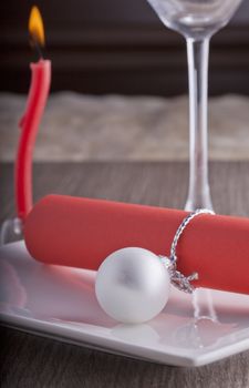 Red paper with Christmas decoration over white plate