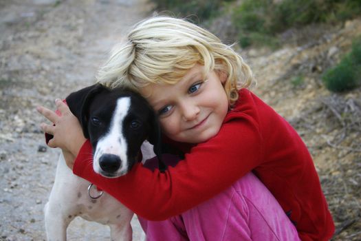 A young girl hugging a puppy