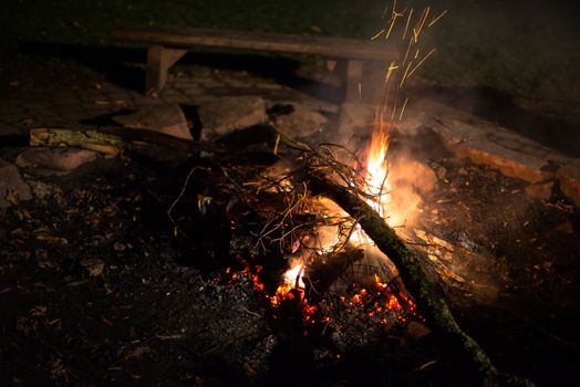Flames of a cozy campfire flicker in a light breeze
