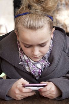 Child texting or playing game on smart phone