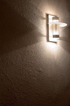 Modern lamp on concrete wall with great shadows