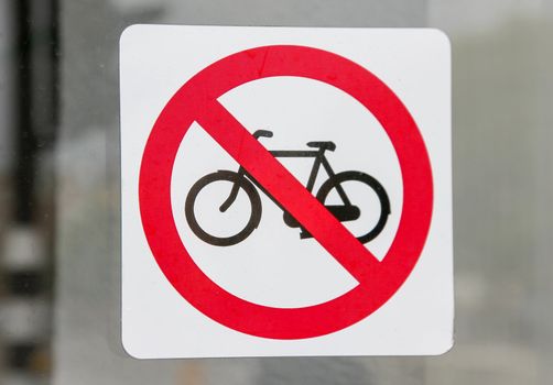 Detail of curious prohibited park bikes sticker in a glass shop of Amsterdam