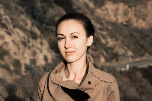 Portrait of a beautiful brunette on a background of mountain road