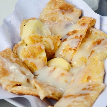 Dessert style of fried Roti with banana cooking on the street in Bangkok, Thailand