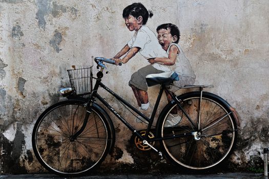 a graffiti of 2 children cycling