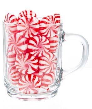 hard red and white candy mints in a transparent cup