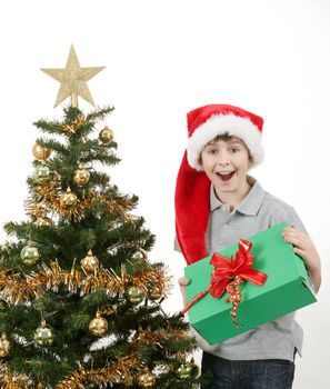 surprised boy in santa hat with christmas present on white background