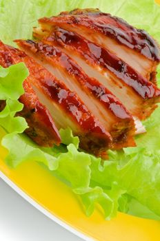Slices of Juicy Barbecue Chicken Breast with Lettuce on Yellow Plate closeup