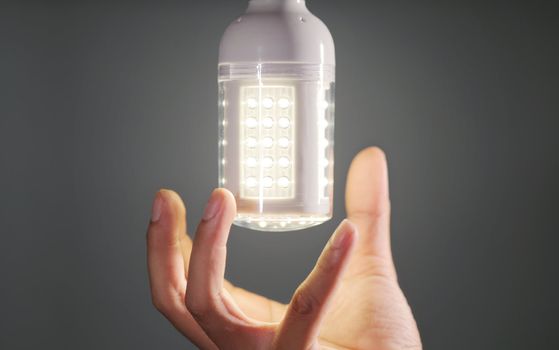 hand replacing modern led light bulb. Go green concept
