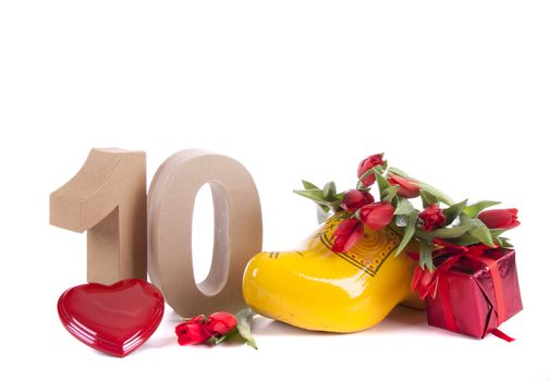Number of age in a colorful studio setting and Dutch looking attributes like a clog woonden shoe and tulips