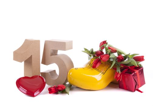 Number of age in a colorful studio setting and Dutch looking attributes like a clog woonden shoe and tulips