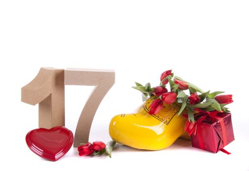 Number of age in a colorful studio setting and Dutch looking attributes like a clog woonden shoe and tulips
