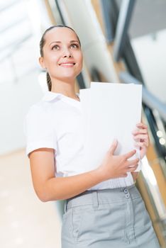 Portrait of a successful business woman in the office, holding papers and smile