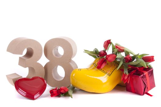 Number of age in a colorful studio setting and Dutch looking attributes like a clog woonden shoe and tulips