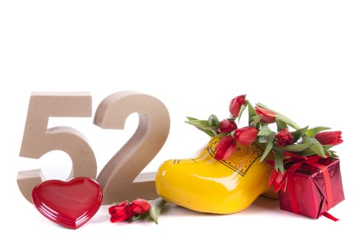 Number of age in a colorful studio setting and Dutch looking attributes like a clog woonden shoe and tulips