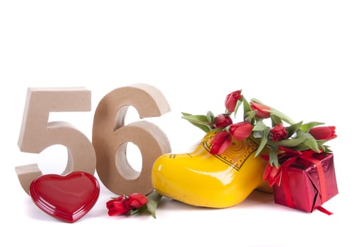 Number of age in a colorful studio setting and Dutch looking attributes like a clog woonden shoe and tulips