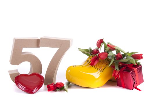 Number of age in a colorful studio setting and Dutch looking attributes like a clog woonden shoe and tulips