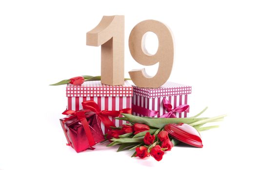 Number of age in a colorful studio setting with a red heart and gifts and tulips