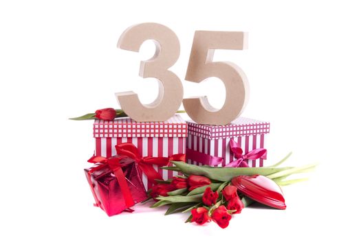 Number of age in a colorful studio setting with a red heart and gifts and tulips