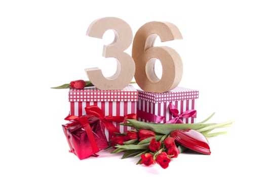 Number of age in a colorful studio setting with a red heart and gifts and tulips