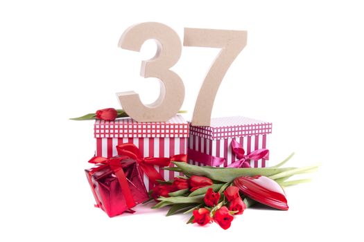 Number of age in a colorful studio setting with a red heart and gifts and tulips