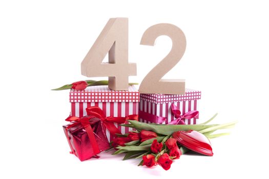 Number of age in a colorful studio setting with a red heart and gifts and tulips